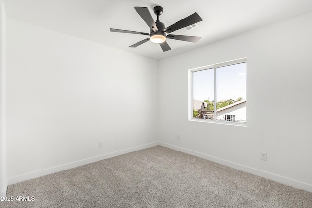 carpeted spare room featuring ceiling fan and baseboards