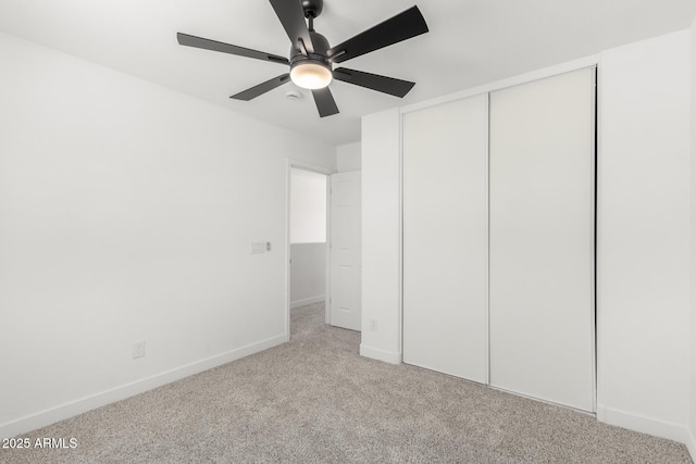 unfurnished bedroom featuring baseboards, a ceiling fan, carpet flooring, and a closet