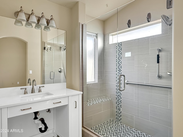 bathroom featuring vanity, a shower with door, and a wealth of natural light