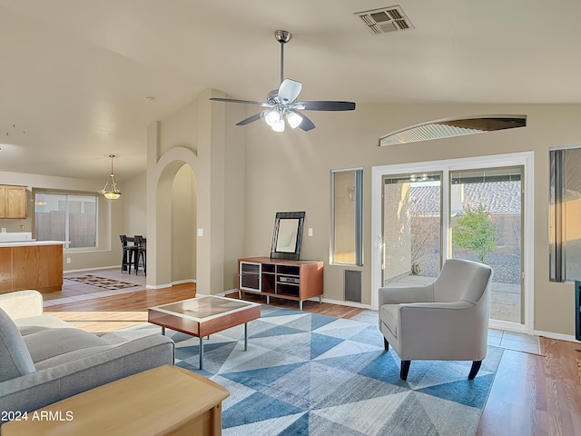 living room with light wood-type flooring, vaulted ceiling, and ceiling fan