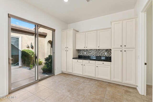 kitchen featuring decorative backsplash, white cabinetry, and light tile patterned floors