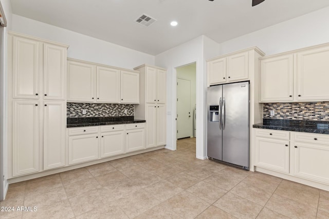 kitchen featuring decorative backsplash, dark stone counters, ceiling fan, stainless steel fridge with ice dispenser, and light tile patterned flooring