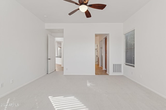 interior space featuring light carpet and ceiling fan