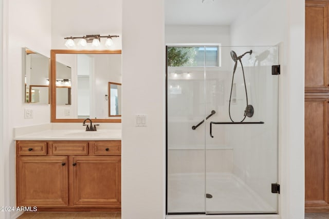 bathroom featuring tile patterned flooring, vanity, and a shower with shower door