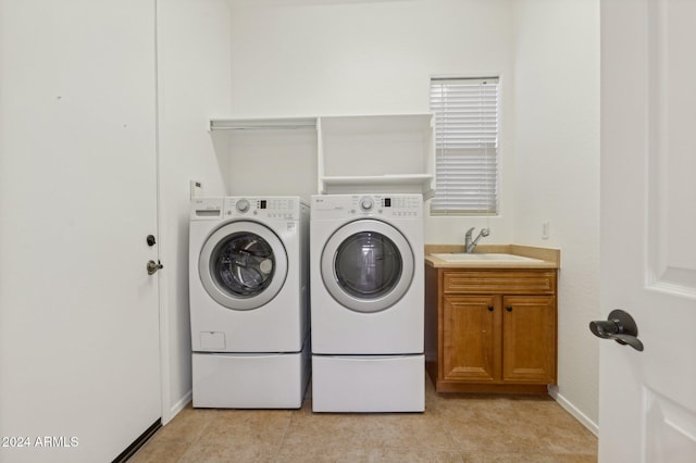 laundry room featuring cabinets, independent washer and dryer, and sink