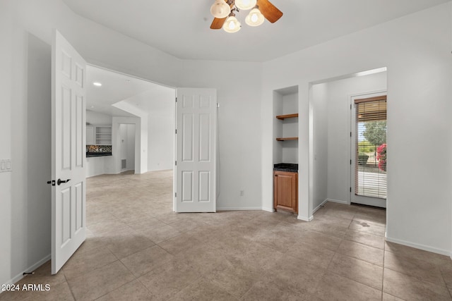 unfurnished living room with ceiling fan and light tile patterned flooring