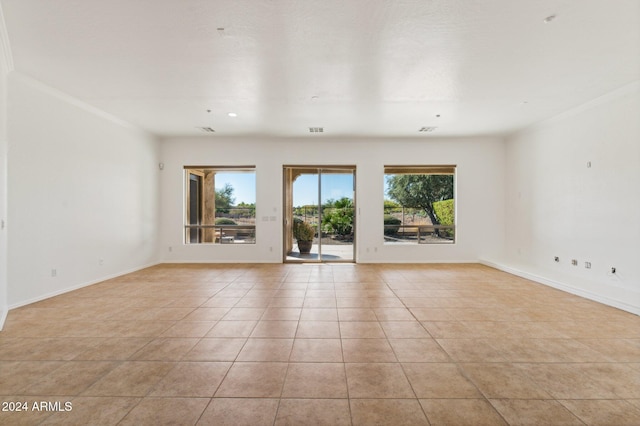 spare room featuring ornamental molding and light tile patterned floors