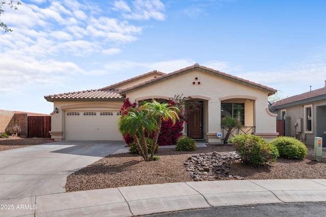 mediterranean / spanish home featuring stucco siding, a tiled roof, driveway, and a garage