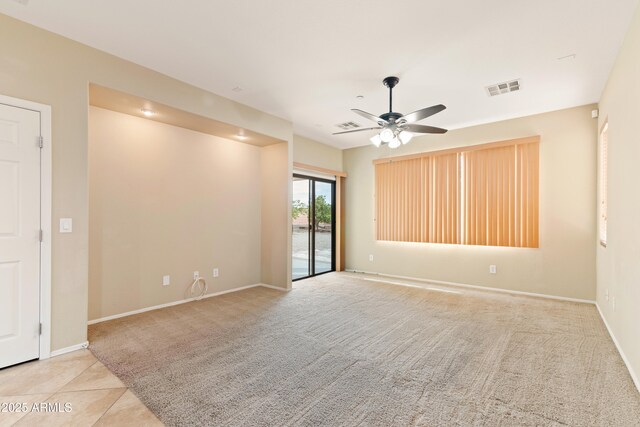 spare room with visible vents, baseboards, a ceiling fan, and carpet floors