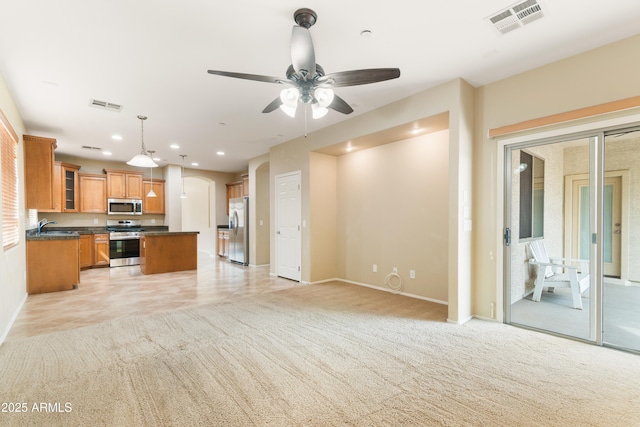 kitchen featuring light carpet, visible vents, appliances with stainless steel finishes, and open floor plan