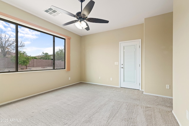 carpeted empty room featuring baseboards, visible vents, and ceiling fan