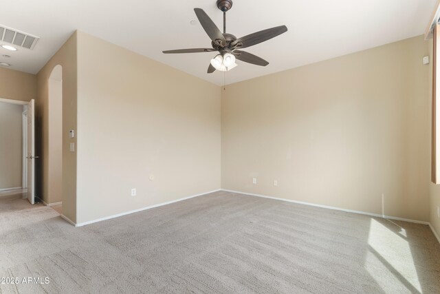 spare room with visible vents, arched walkways, baseboards, and ceiling fan