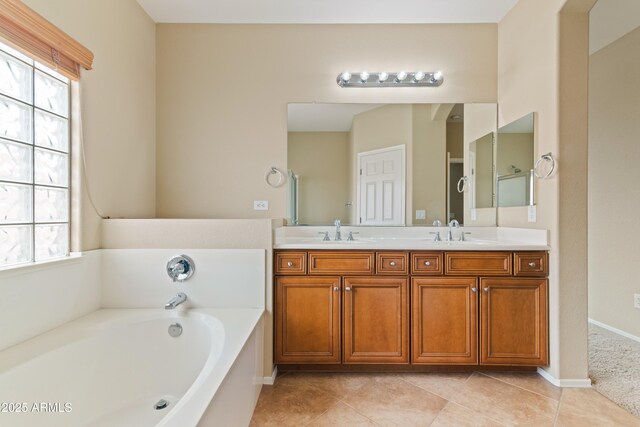 full bath featuring a bath, a wealth of natural light, and a sink