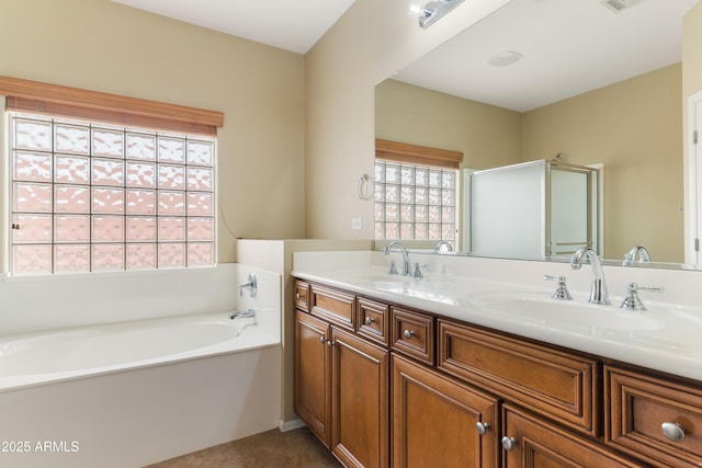 bathroom featuring a sink, visible vents, a garden tub, and double vanity