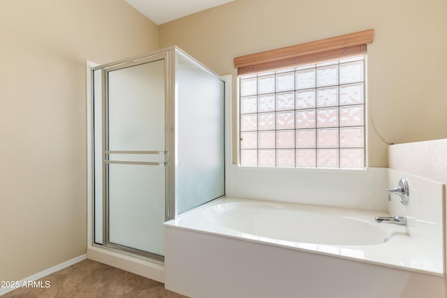 full bathroom featuring tile patterned floors, baseboards, a bath, and a shower stall