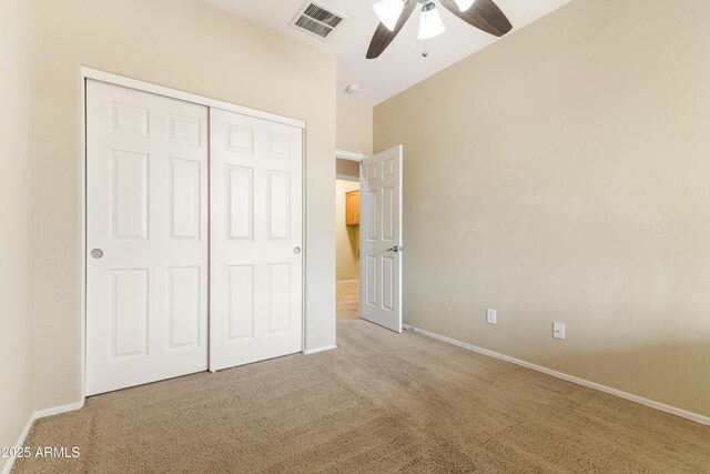 unfurnished bedroom featuring visible vents, baseboards, carpet floors, a closet, and a ceiling fan