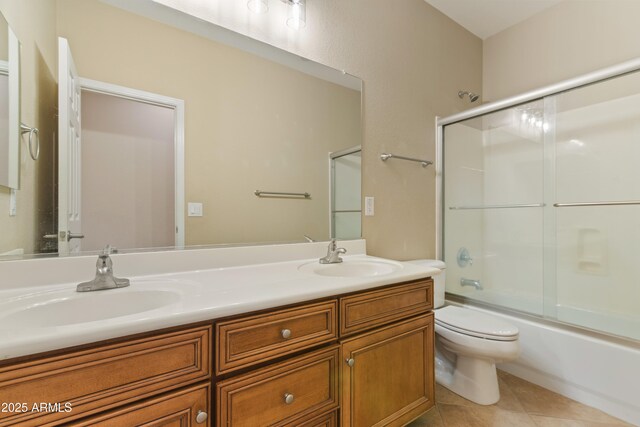 full bathroom with tile patterned floors, double vanity, toilet, and a sink