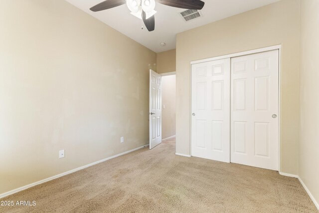 unfurnished bedroom with baseboards, visible vents, ceiling fan, a closet, and carpet flooring