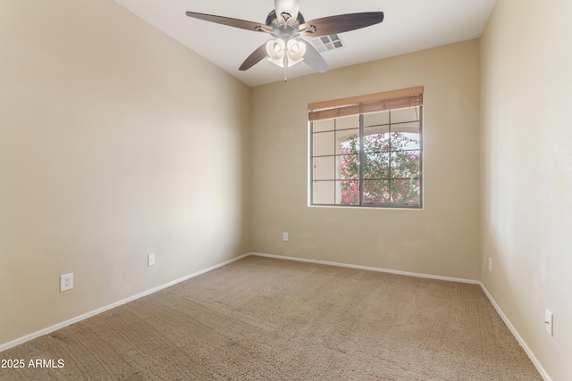 carpeted empty room with visible vents, baseboards, and ceiling fan