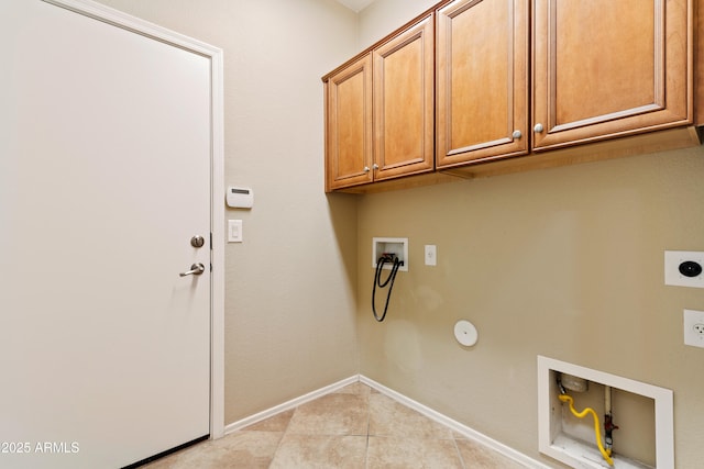 washroom with baseboards, washer hookup, light tile patterned flooring, cabinet space, and hookup for an electric dryer