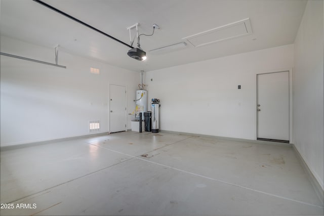 garage featuring baseboards, a garage door opener, and water heater