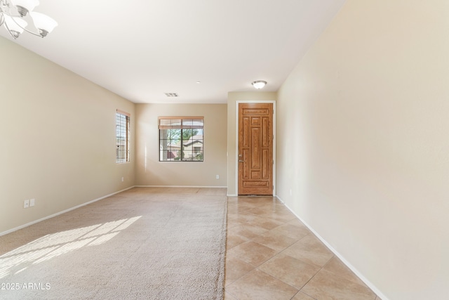 spare room with light tile patterned floors, visible vents, and baseboards