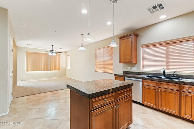 kitchen with dark countertops, visible vents, a sink, and stainless steel dishwasher