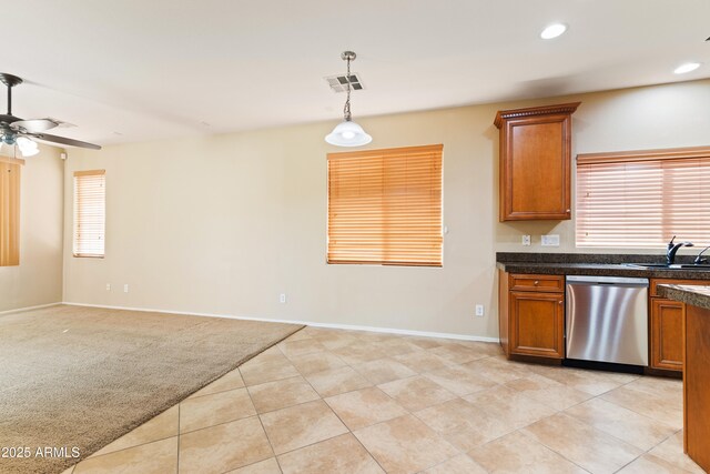 kitchen with dark countertops, visible vents, ceiling fan, brown cabinetry, and stainless steel dishwasher