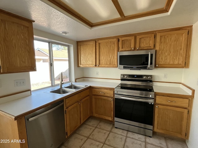 kitchen with a raised ceiling, sink, a textured ceiling, light tile patterned flooring, and stainless steel appliances