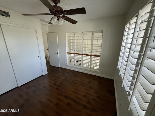 unfurnished bedroom featuring ceiling fan, a closet, and dark hardwood / wood-style floors