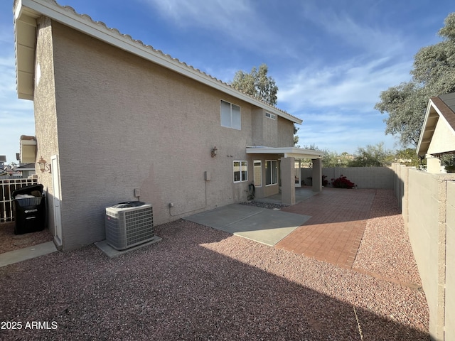 back of property with a patio area and central AC