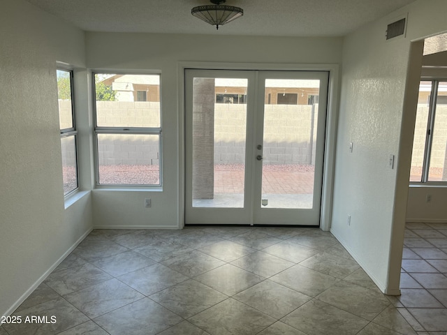 interior space with french doors and light tile patterned flooring