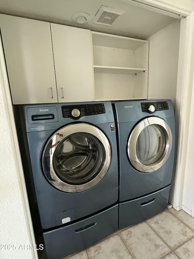 laundry area with light tile patterned floors and washer and dryer