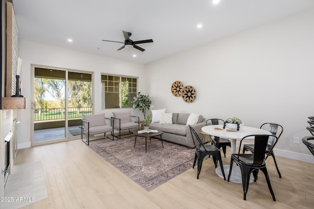 living room featuring light hardwood / wood-style floors and ceiling fan