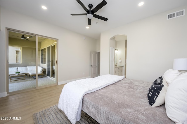 bedroom featuring ensuite bathroom, ceiling fan, and light wood-type flooring