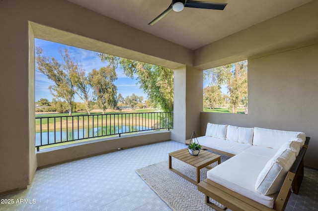 balcony with a water view, outdoor lounge area, and ceiling fan