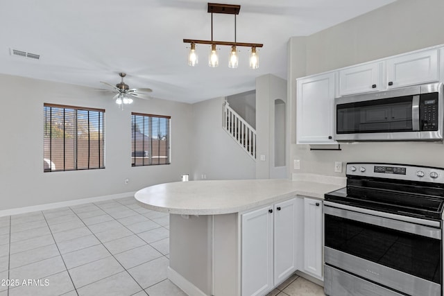 kitchen with white cabinetry, hanging light fixtures, kitchen peninsula, and appliances with stainless steel finishes