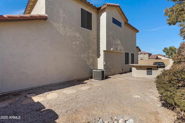 view of side of home with central AC unit and a patio area