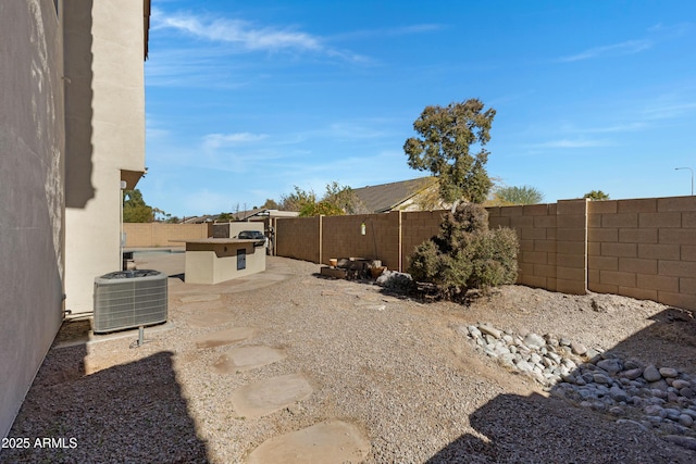 view of yard with exterior kitchen, cooling unit, and a patio area