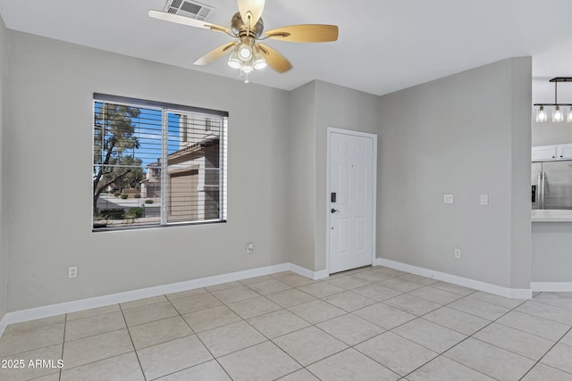 spare room with ceiling fan and light tile patterned floors