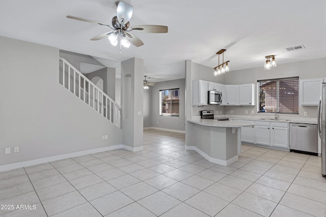 kitchen with white cabinetry, light tile patterned floors, pendant lighting, ceiling fan, and stainless steel appliances