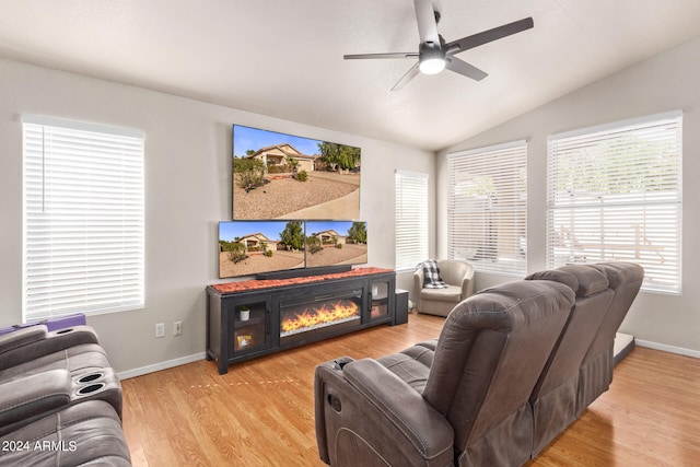 living room featuring lofted ceiling, light wood-type flooring, a wealth of natural light, and a fireplace