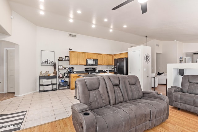 living room featuring sink, high vaulted ceiling, light hardwood / wood-style floors, and ceiling fan