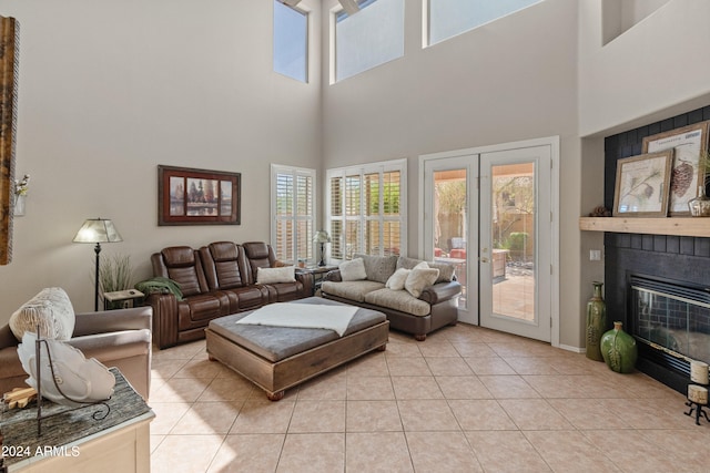 tiled living room featuring a high ceiling and a tiled fireplace