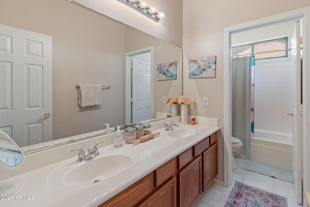 full bathroom with shower / tub combo with curtain, tile patterned floors, vanity, and toilet