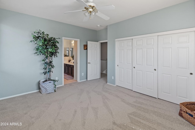 unfurnished bedroom with ceiling fan, a closet, ensuite bath, and light carpet