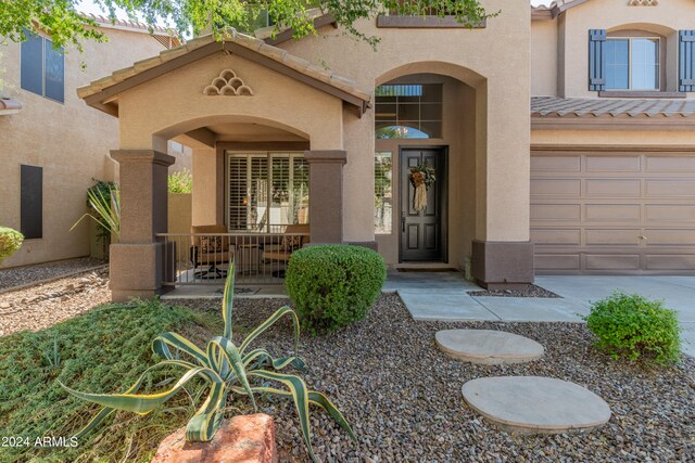 property entrance with covered porch and a garage