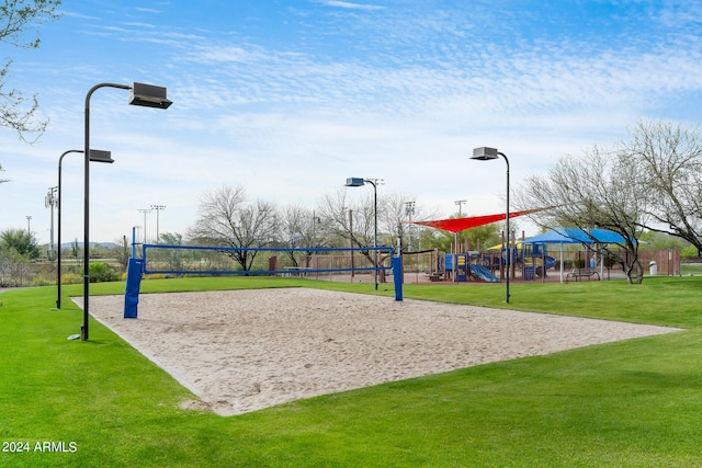 view of community featuring a playground, a yard, and volleyball court