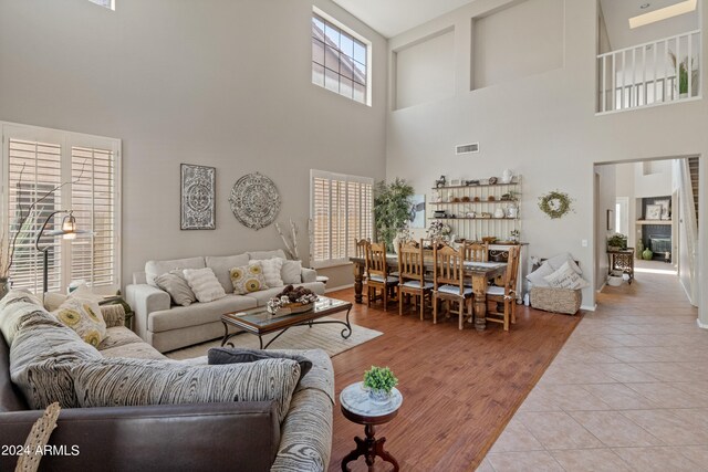 living room featuring light wood-type flooring and a high ceiling