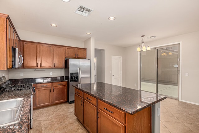 kitchen with brown cabinets, a kitchen island, visible vents, and stainless steel appliances
